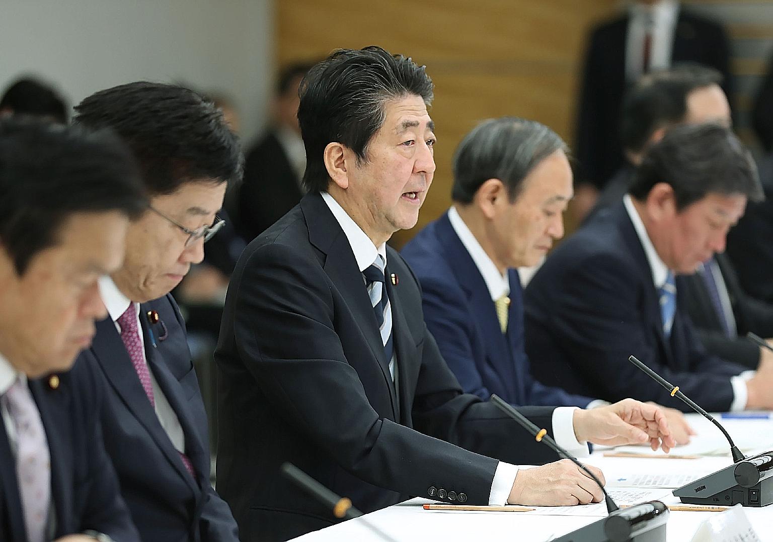 Japan's Prime Minister Shinzo Abe and Health Minister Katsunobu Kato (second from left) at a meeting on the coronavirus in Tokyo yesterday. Japan is considering using Avigan, an anti-flu drug, to treat coronavirus patients. PHOTO: AGENCE FRANCE-PRESS