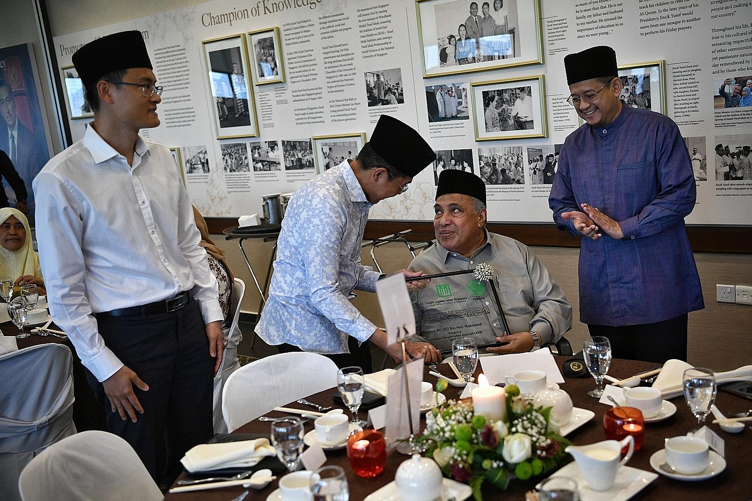 Senior Minister of State for Defence and Foreign Affairs Maliki Osman presenting a plaque to Ustaz Ali Haji Mohamed at a ceremony at Masjid Yusof Ishak yesterday. On the left is Muis chief executive Esa Masood and on the right the Mufti of Singapore,