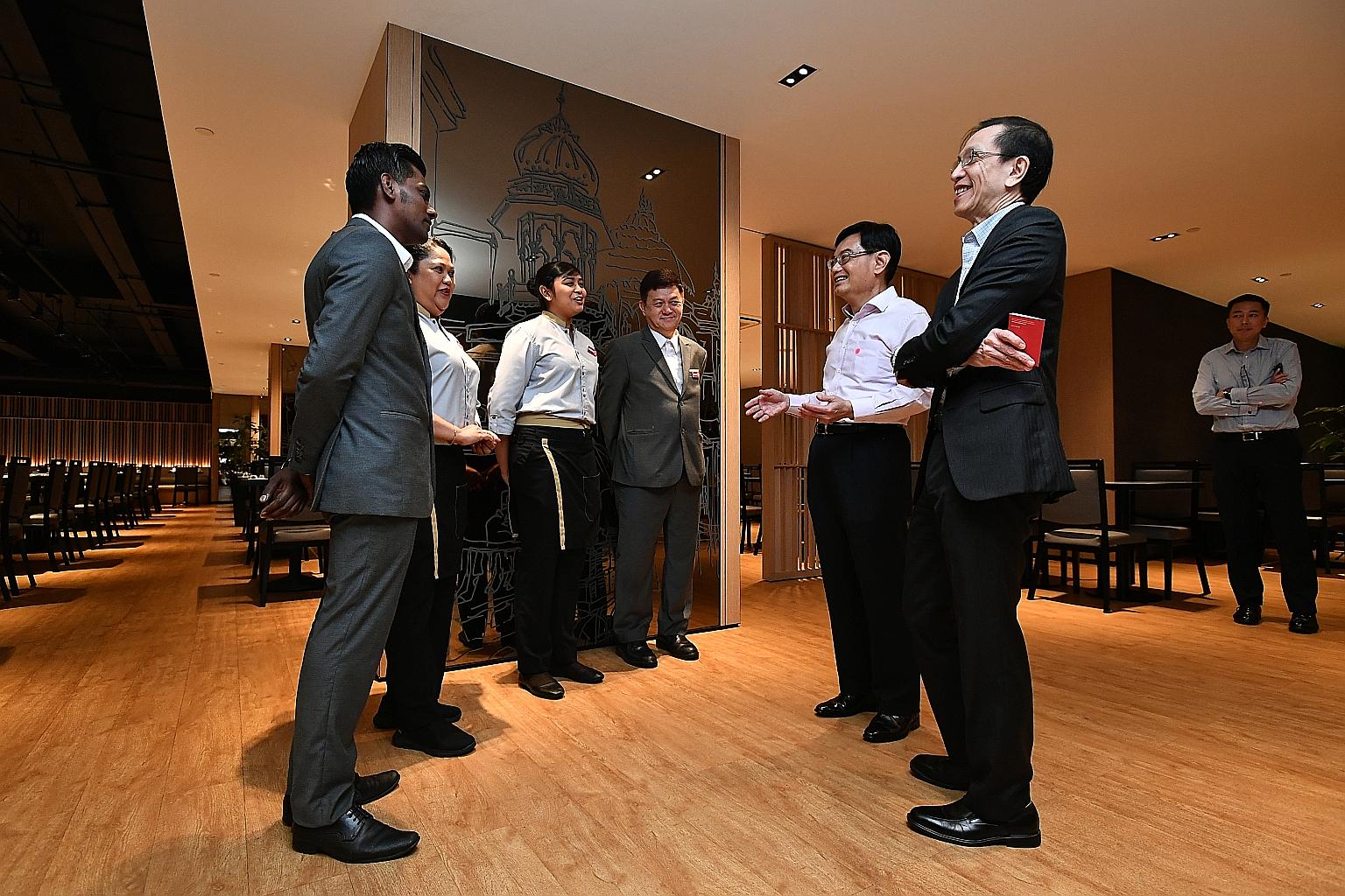 Deputy Prime Minister Heng Swee Keat (fifth from left) speaking to Parkroyal on Kitchener Road's (from left) Mr Mageswaran Krishnan, 30, assistant restaurant manager; Ms Kamaliah Bonawi, 52, F&B service agent; Ms Helen Harip Wibowo, 24, outlet captai