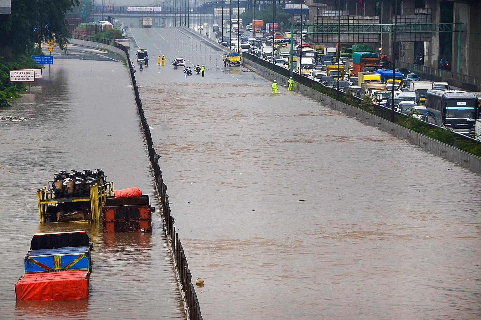 Motorists trapped on a flooded toll road (above) in Bekasi, West Java, while hundreds of residents in Jakarta (left) had to be evacuated by search and rescue teams yesterday, after torrential rain pounded Indonesia's capital. PHOTOS: AGENCE FRANCE-PR
