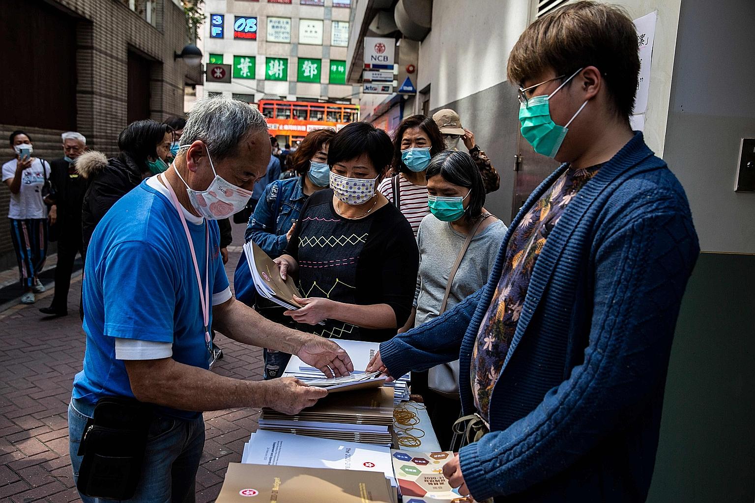 People queueing for a copy of the government's annual budget booklet in Hong Kong yesterday. The pan-democracy camp was unhappy over the additional $897 million funding earmarked for the police. PHOTO: AGENCE FRANCE-PRESSE