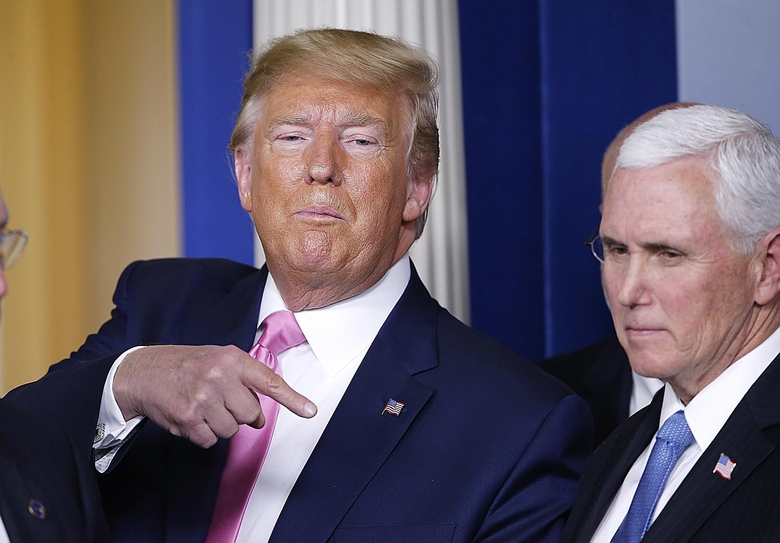 US President Donald Trump gesturing at Vice-President Mike Pence as they left after a news conference at the White House on Wednesday. PHOTO: EPA-EFE