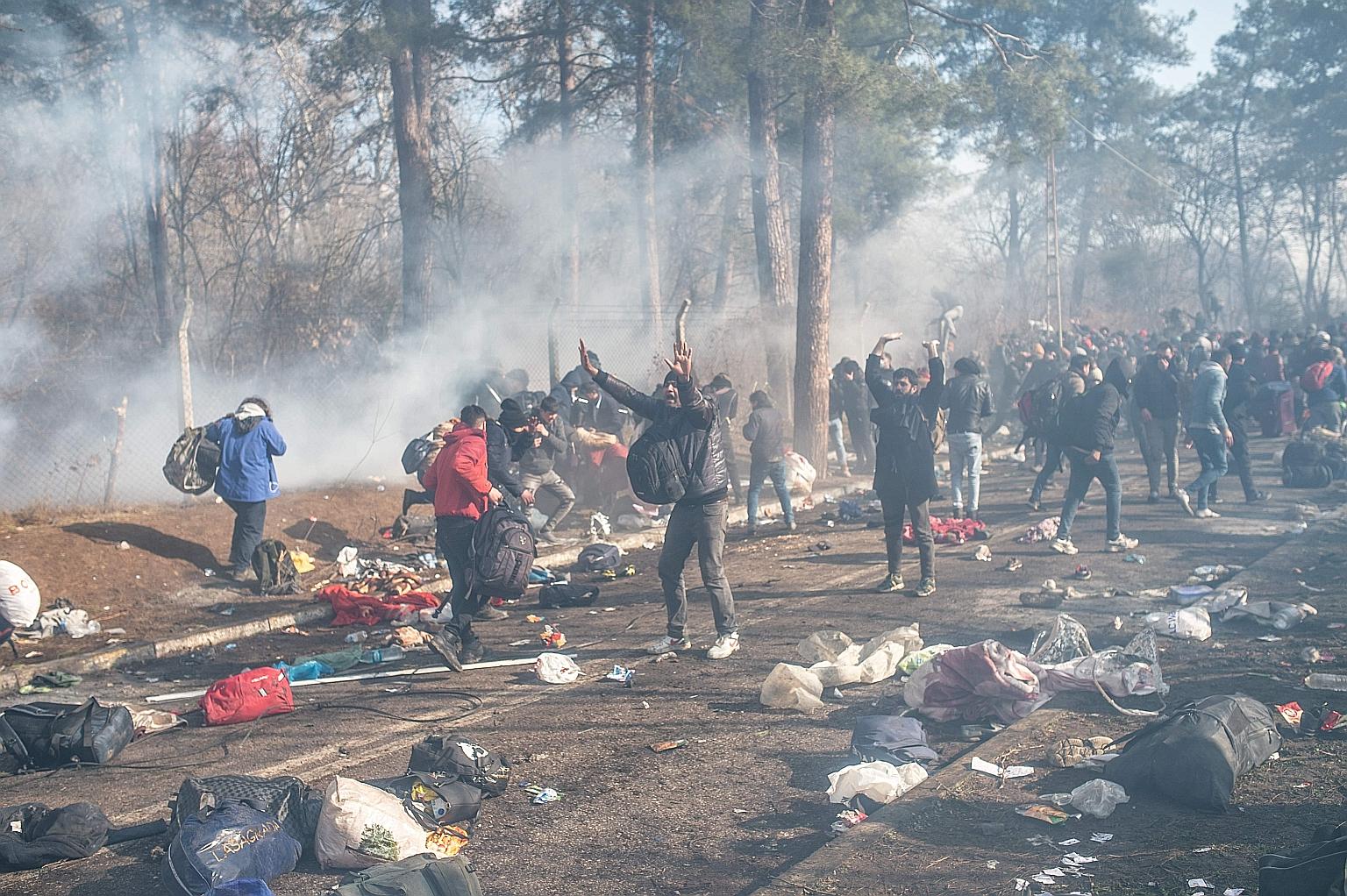 Migrants amid tear gas on the Turkey-Greece border at Pazarkule yesterday. Turkish President Recep Tayyip Erdogan vowed yesterday to allow the refugees to travel on to Europe from Turkey, which he said can no longer handle new waves of people fleeing