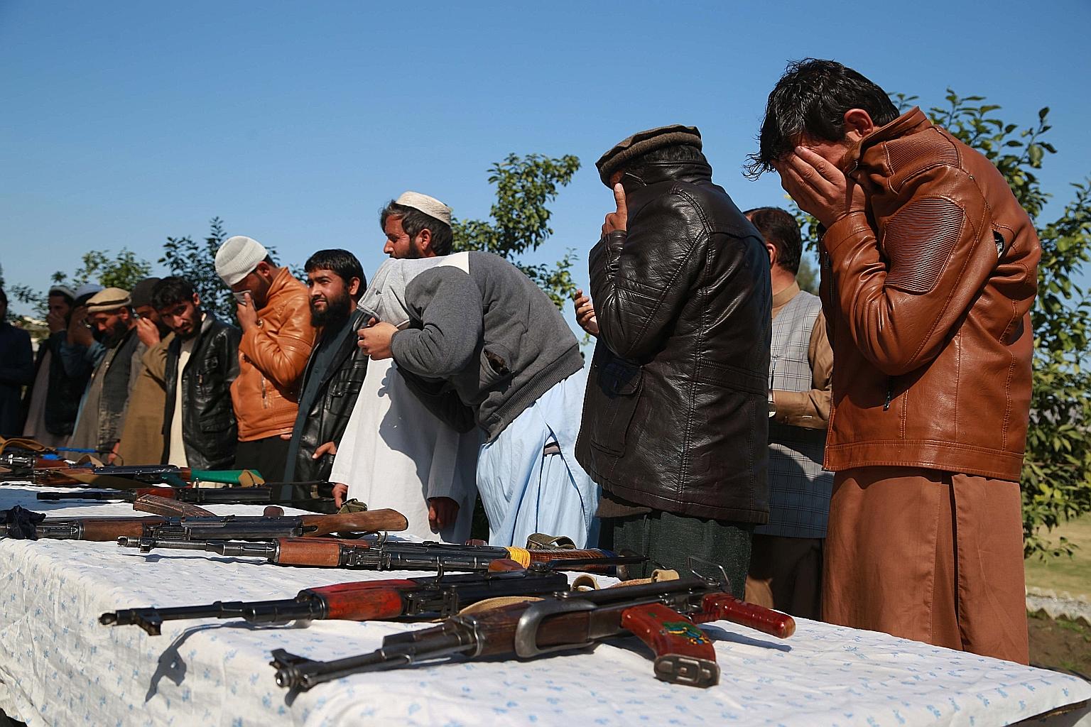 Former militants surrendering their arms in Jalalabad, Afghanistan, yesterday. Taleban political chief Mullah Abdul Ghani Baradar has met foreign ministers from several countries in a bid to gain international legitimacy.