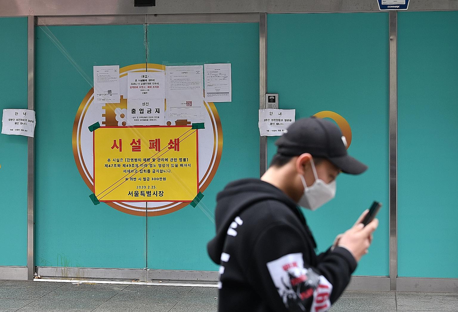 A man walking past a branch of the Shincheonji Church of Jesus, the Temple of the Tabernacle of the Testimony, in Seoul. The church has been temporarily closed by the South Korean government to help prevent the spread of the coronavirus after a large