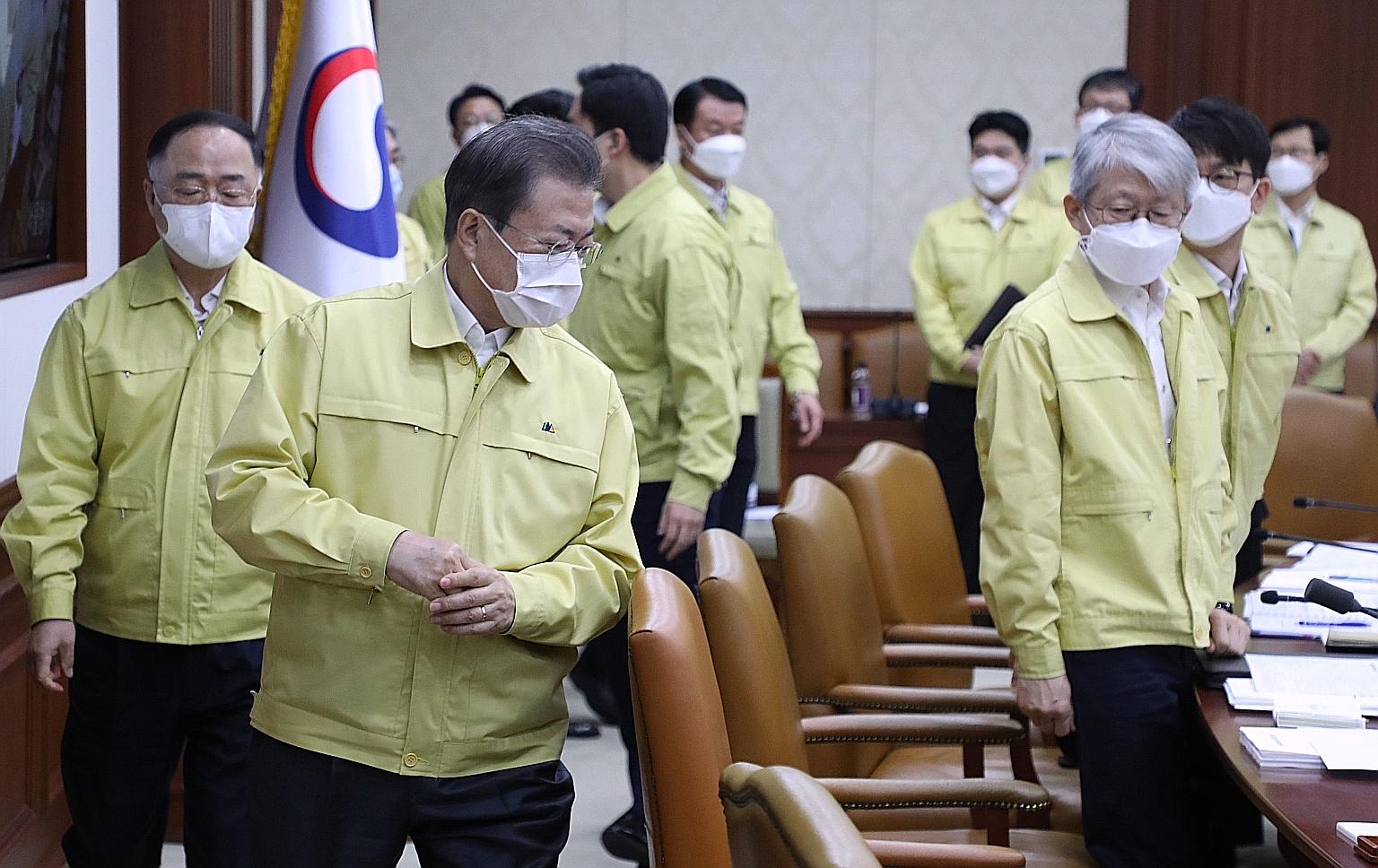 South Korean President Moon Jae-in (second from left) and his ministers at a Cabinet meeting in Seoul yesterday. He revealed plans to provide 30 trillion won (S$34.9 billion) in funding to fight the virus, and urged a "bold fiscal injection" to cushi