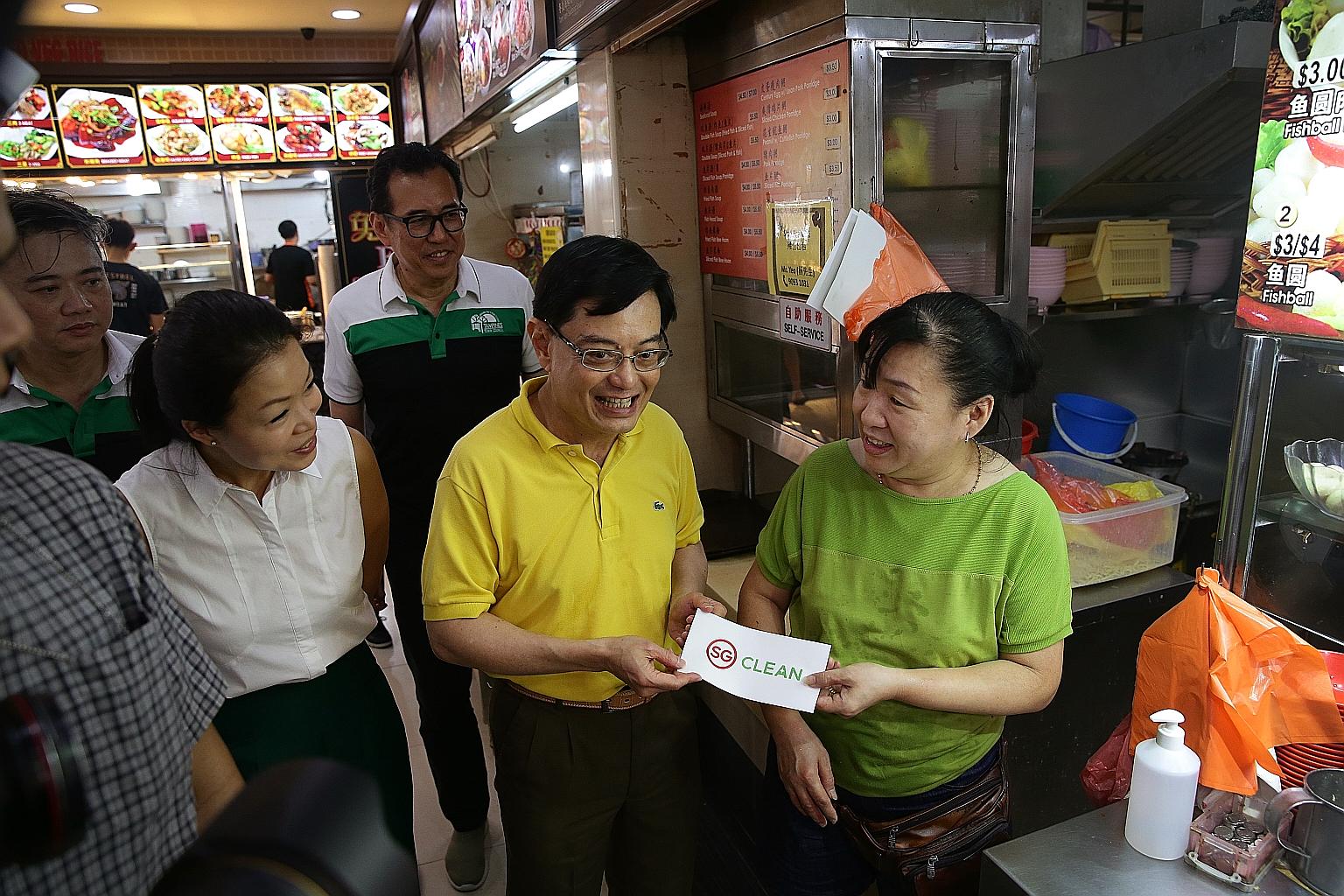 Deputy Prime Minister Heng Swee Keat and Tampines GRC MP Cheng Li Hui with Madam Lim Puay Lang, 50, owner of a minced meat noodle stall which received the SG Clean certification, at a coffee shop in Tampines yesterday. Certification means stalls have