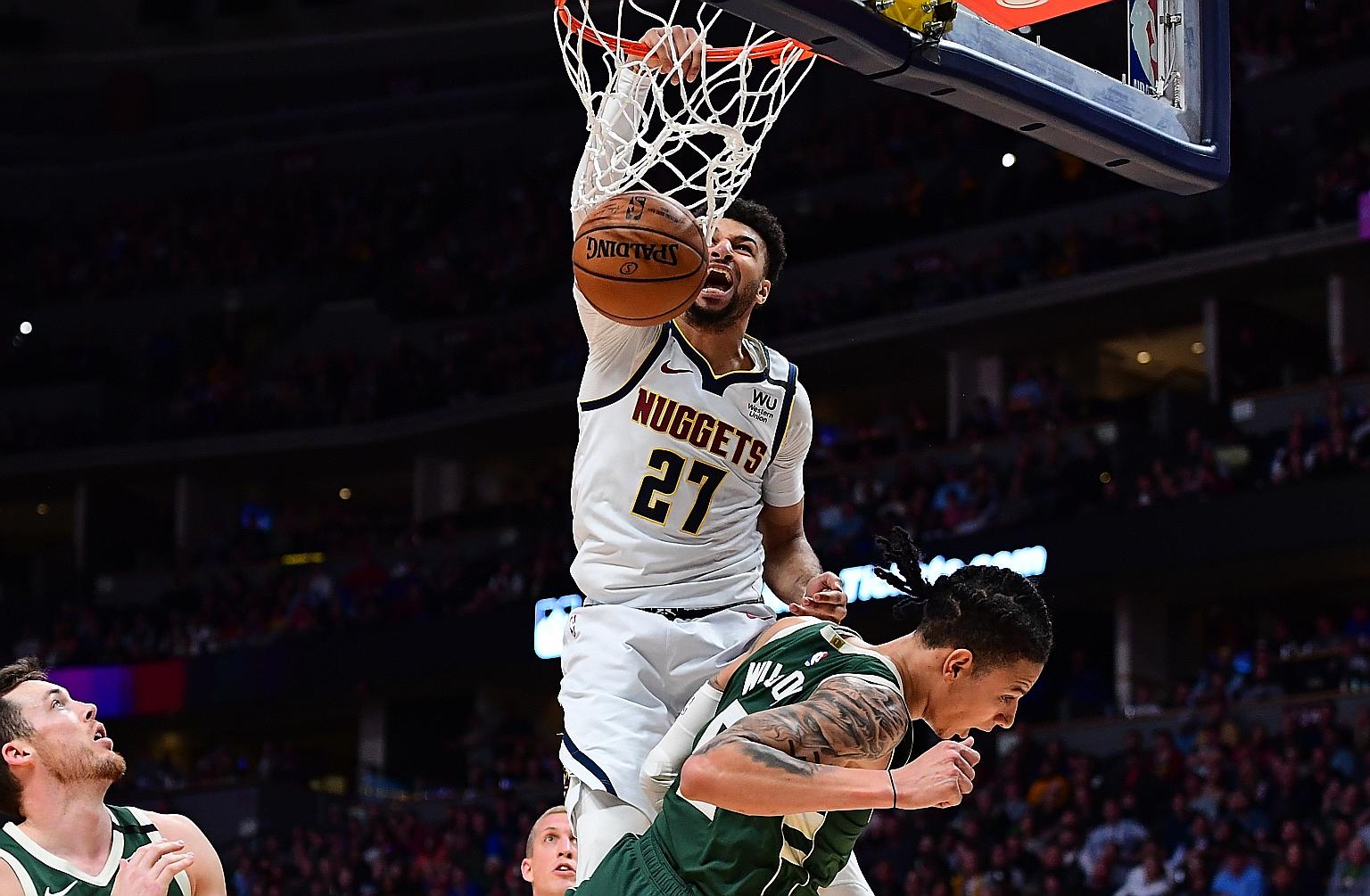 Denver Nuggets' Jamal Murray finishing off a basket over Milwaukee Bucks' D.J. Wilson on Monday. PHOTO: REUTERS