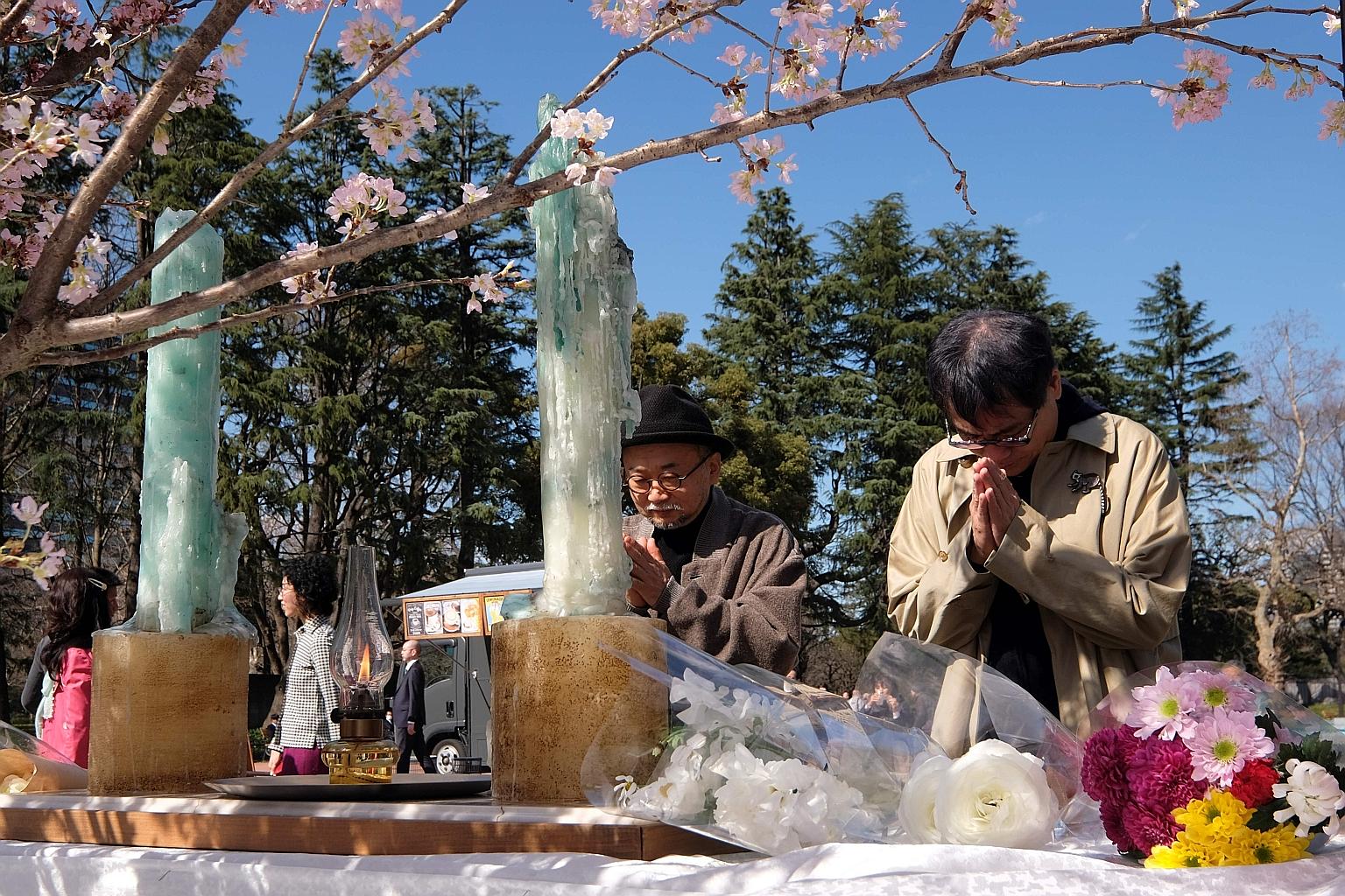 Silent prayers being offered at an altar for victims of the 2011 Japan earthquake and tsunami at a park in Tokyo yesterday.