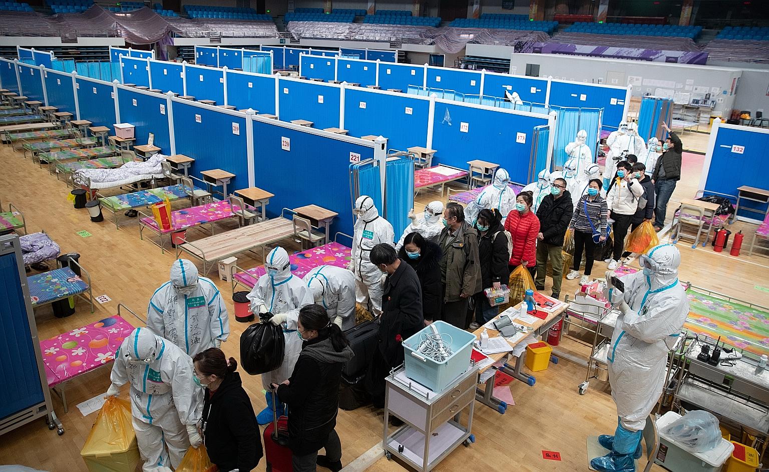 Staff and patients leaving, after all patients were discharged from Wuhan's Wuchang Fangcang hospital, which was temporarily set up to treat coronavirus patients. PHOTO: EPA-EFE