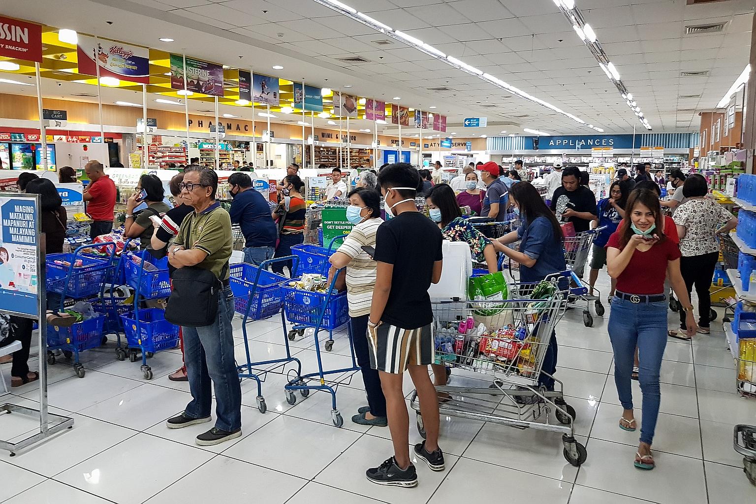 Shoppers endured long queues at checkout counters in groceries and supermarkets in Manila yesterday as word that a lockdown would be enforced set off panic buying across Metro Manila. Shelves were emptied quickly, with sanitisers, disinfectants, rice