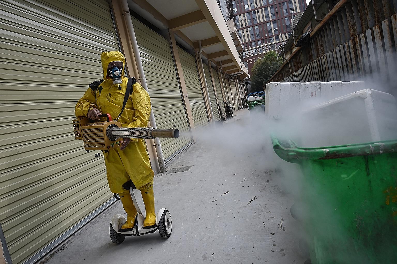 A worker disinfecting a residential area in the Chinese city of Wuhan, the epicentre of the outbreak, on Wednesday. China has imposed strict quarantine and travel restrictions on hundreds of millions of citizens and foreigners.