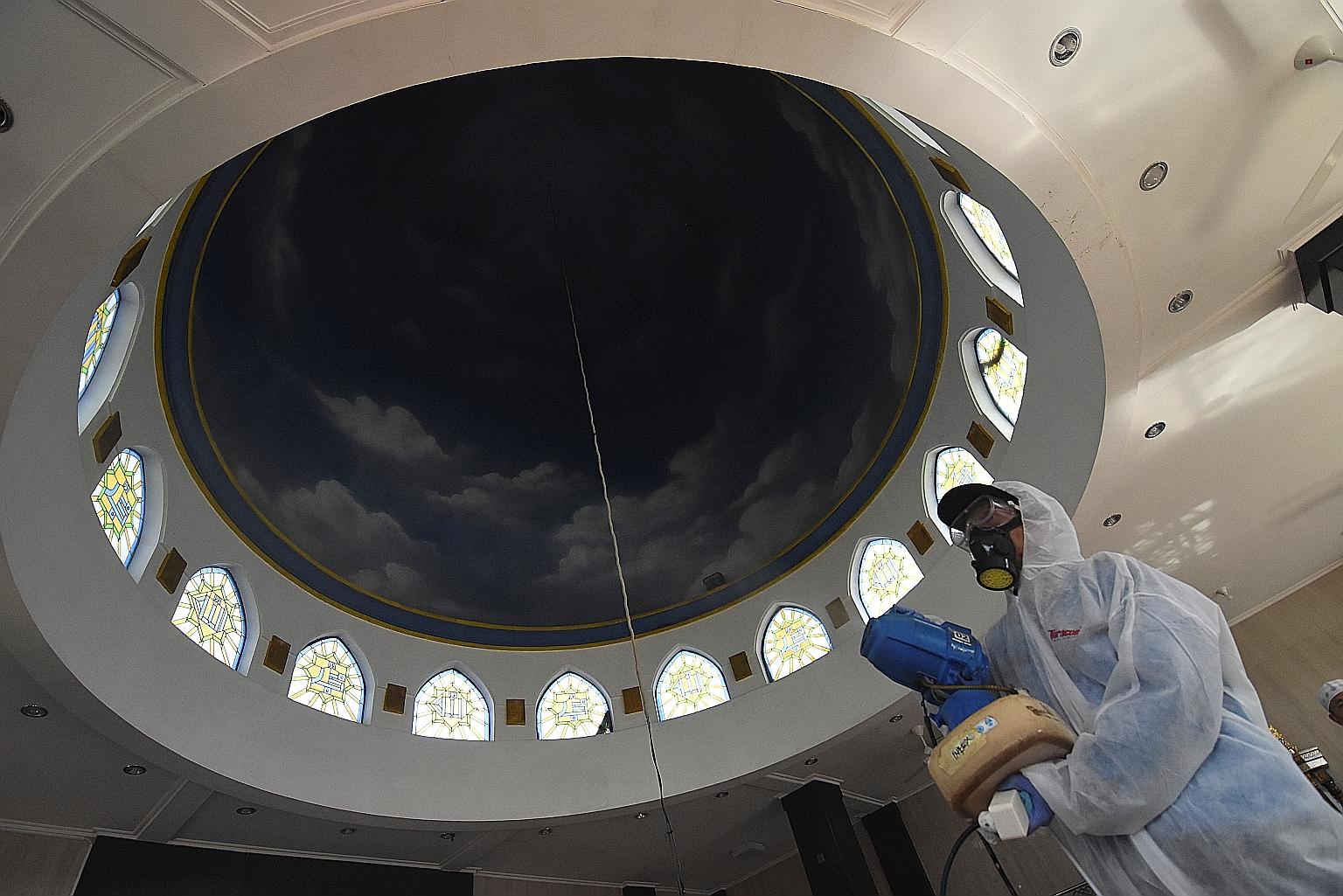 A medical personnel in a protective suit spraying disinfectant in a Jakarta mosque yesterday, amid the coronavirus outbreak, in this picture taken by Antara Foto. Despite only 34 confirmed cases among its 270 million people, Indonesia's economy has b