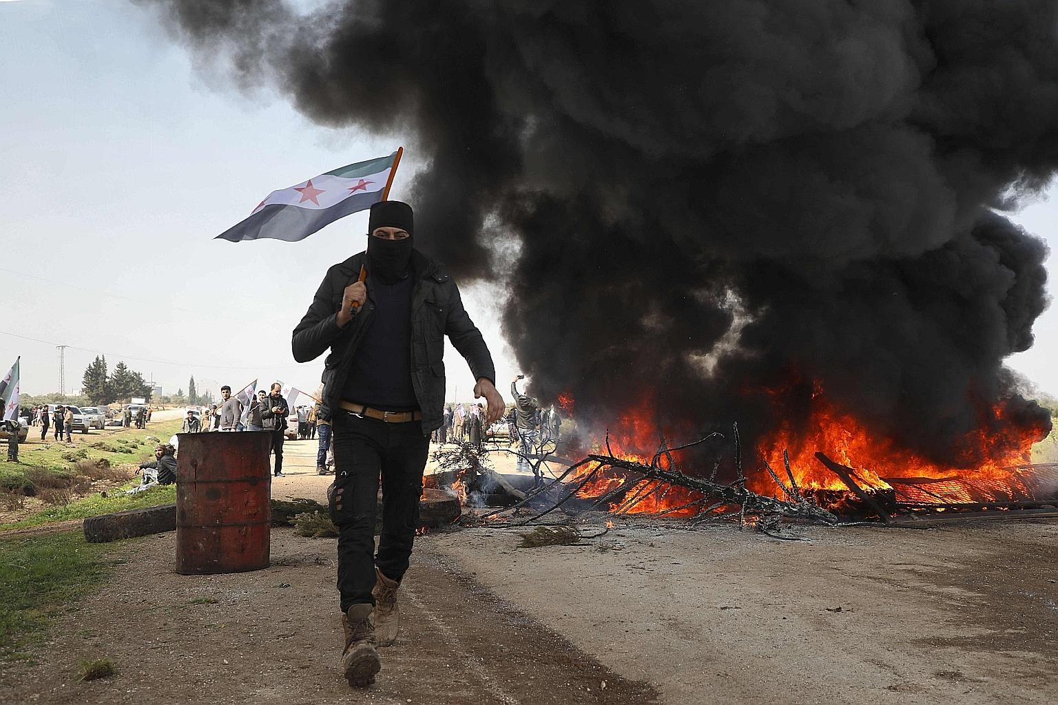 Syrians burning tyres yesterday to try and block traffic on the key M4 highway linking the northern provinces of Aleppo and Latakia, before incoming joint Turkish and Russian military patrols.