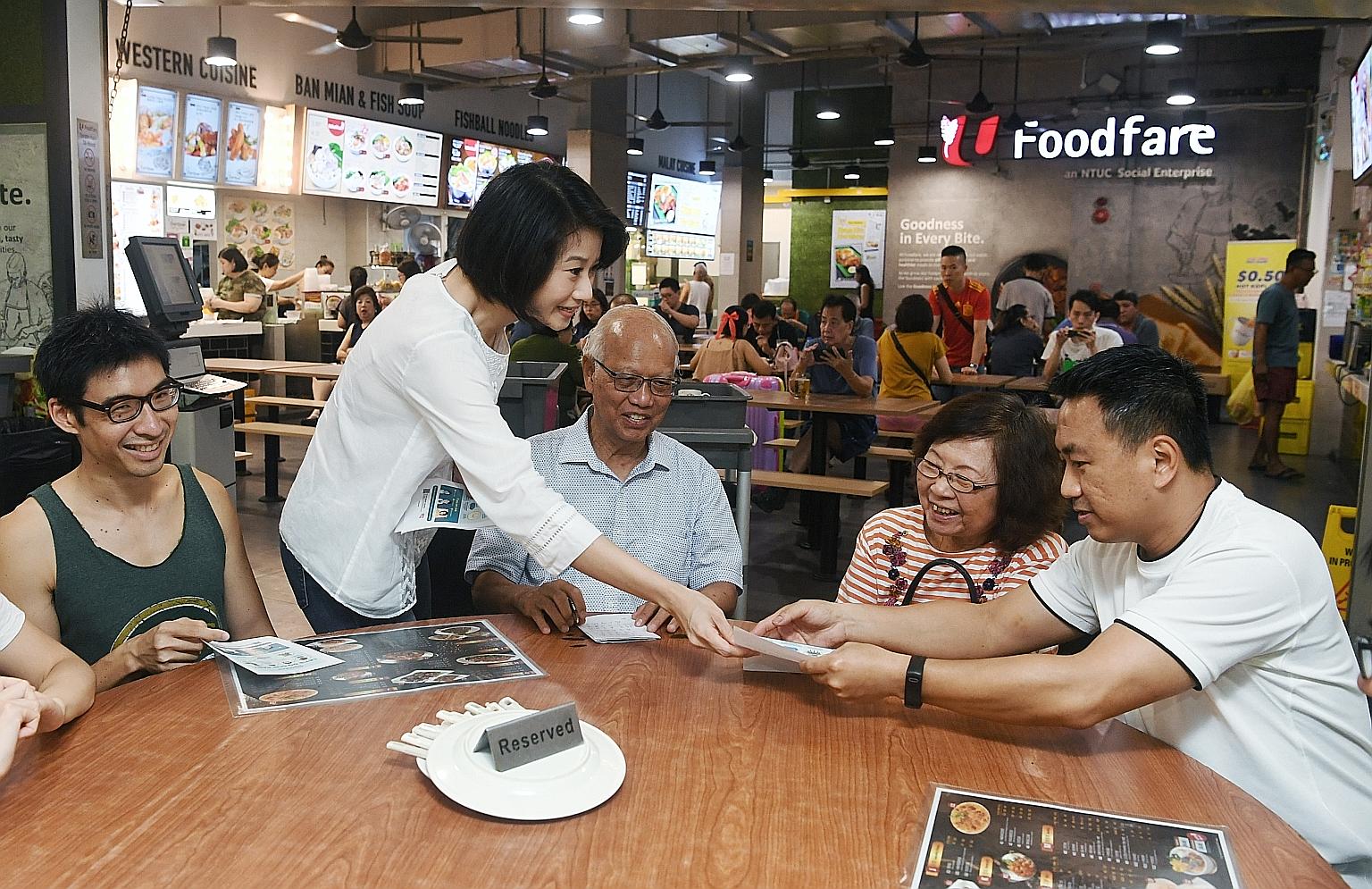 MP Sun Xueling distributing fliers on Covid-19 to residents at a coffee shop in Punggol yesterday. The first-term MP, whose Punggol West ward has been carved out as a single seat, said she has been walking the ground and engaging residents consistent