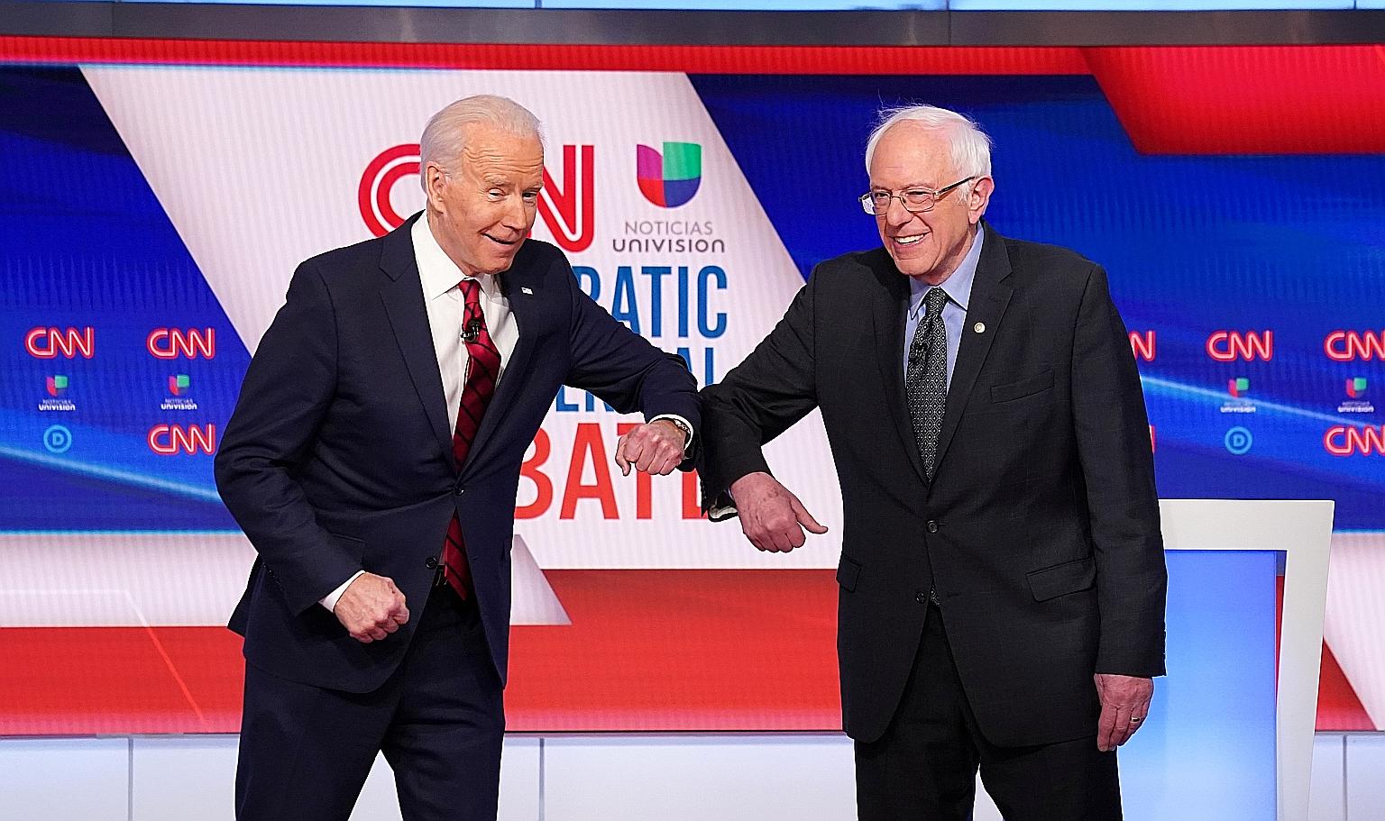 Democratic presidential candidates Joe Biden and Bernie Sanders greeting each other with an elbow bump in place of a handshake before the start of their first one-on-one debate, held in Washington on Sunday. US Democratic primaries will go ahead as p