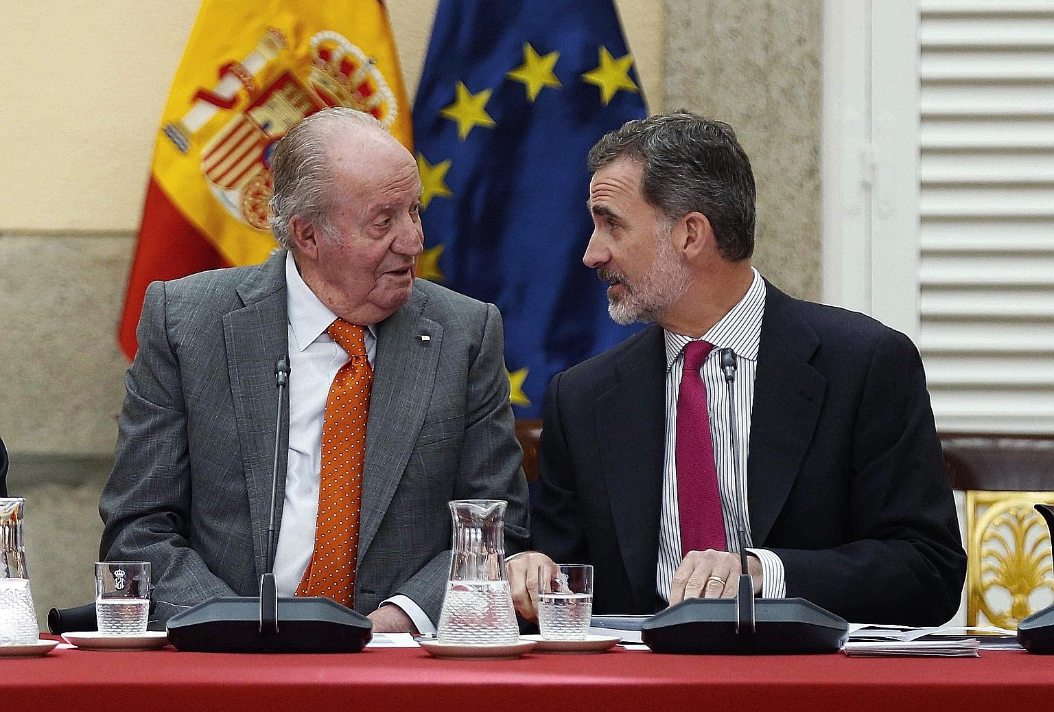 Spain's former king Juan Carlos and his son, King Felipe, in a 2019 photo. The king has stripped his father of his palace allowance.