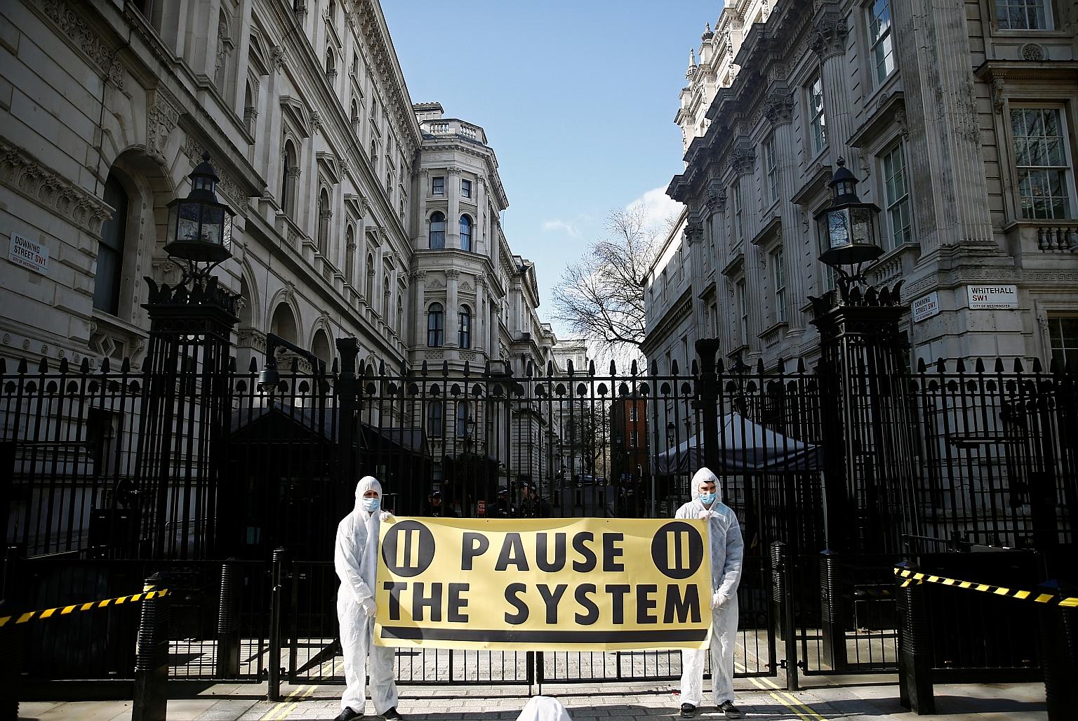 Protesters from organisation "Pause the System" demonstrating against the government's response to the coronavirus outbreak outside Downing Street in London yesterday.