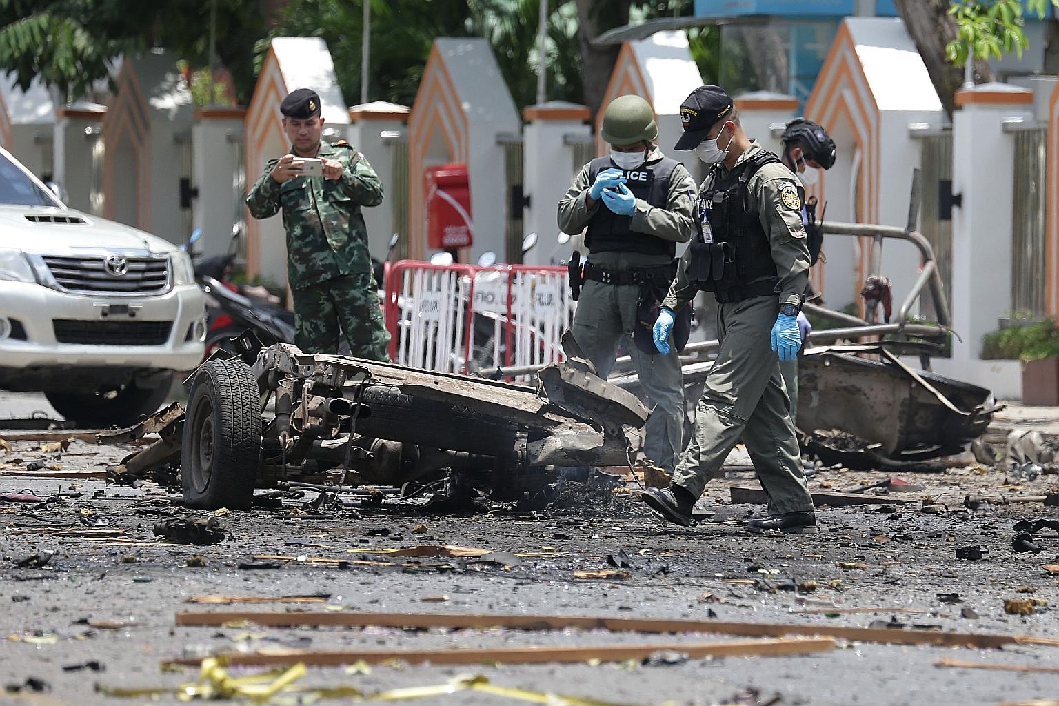 Police investigators inspecting the wreckage of a car bomb following explosions in Thailand's restive south yesterday.