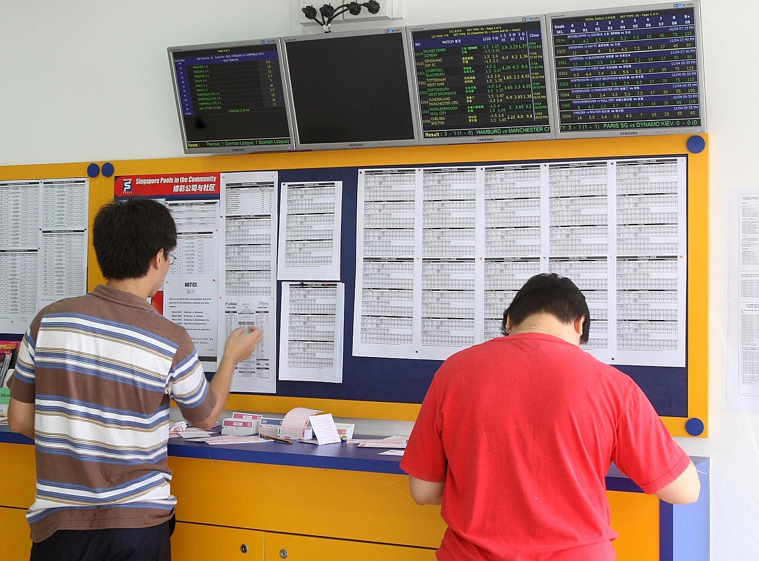 Punters at a Singapore Pools outlet. Legalised football betting was introduced in Singapore - and Asia - in 1999. SHIN MIN DAILY NEWS FILE PHOTO