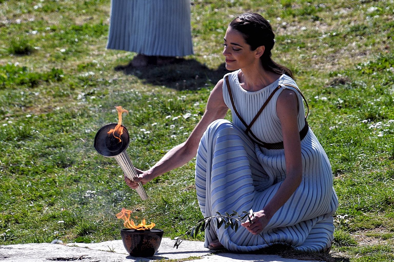 Greek actress Xanthi Georgiou, in the role of the High Priestess, lighting the torch of the Olympic flame in front of Hera Temple in Ancient Olympia, Greece during a ceremony for the Tokyo Games. PHOTO: EPA-EFE