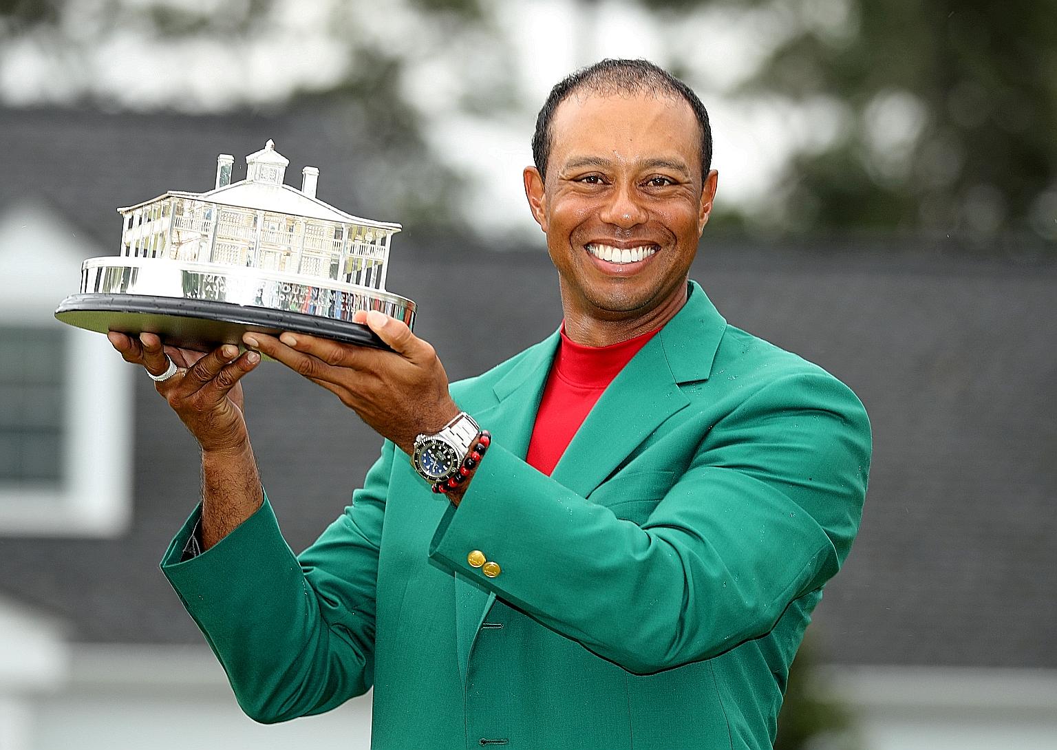 Tiger Woods with the Masters trophy he won last year, his 15th Major triumph. He will have to wait to defend his title after the April 9-12 tournament was postponed. PHOTO: REUTERS