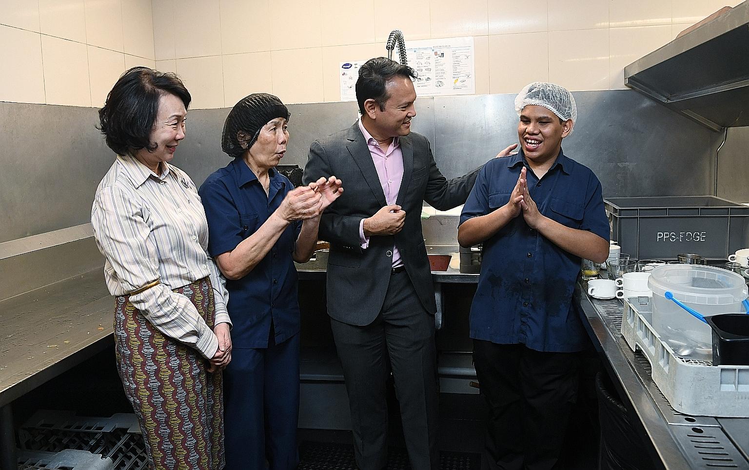 Minister of State for Manpower and National Development Zaqy Mohamad and Pan Pacific Hotels Group executive director (asset, lifestyle and CSR) Wee Wei Ling with staff at Pan Pacific Singapore during a tour of the hotel yesterday.