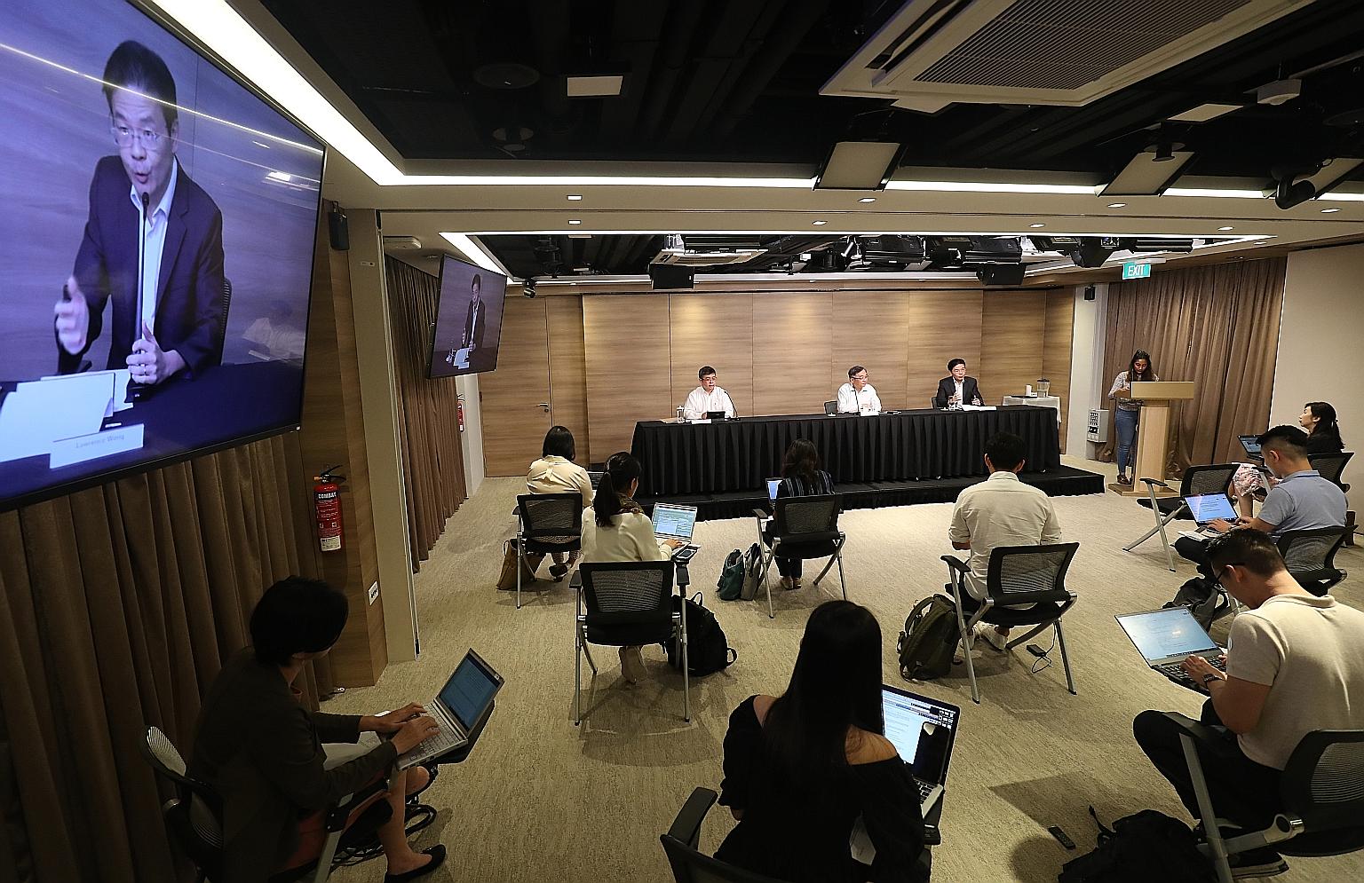 National Development Minister Lawrence Wong (right) speaking at yesterday's news conference. Seated beside him were (from left) Associate Professor Kenneth Mak, director of medical services at the Health Ministry, and Health Minister Gan Kim Yong. Of