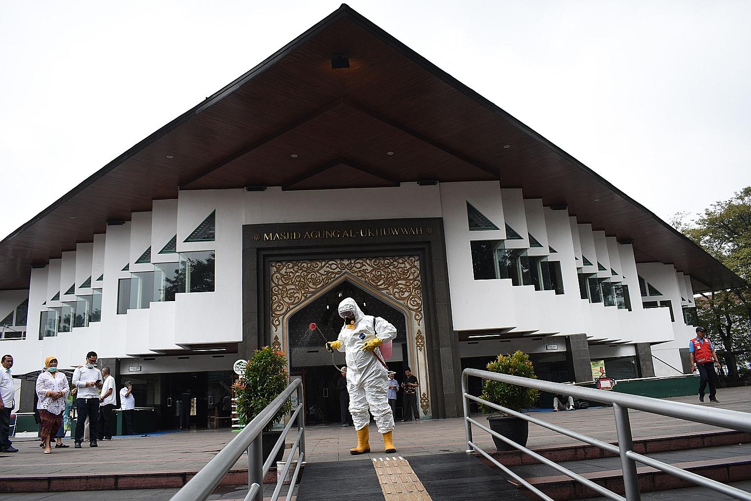 The premises outside a mosque in Bandung, West Java province, being sprayed with disinfectant yesterday. The number of deaths in Indonesia from the virus has risen by six to 25, most of which were in Jakarta. PHOTO: AGENCE FRANCE-PRESSE