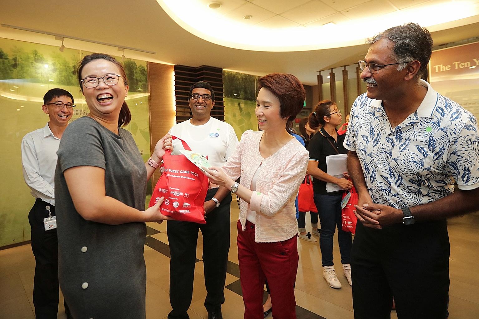 Ms Low Yen Ling, Mayor of South West District, giving out a care pack to Ms Lee Yanting, a 35-year-old medical technologist, at Bukit Batok Polyclinic yesterday. With them is Bukit Batok MP Murali Pillai (at right).