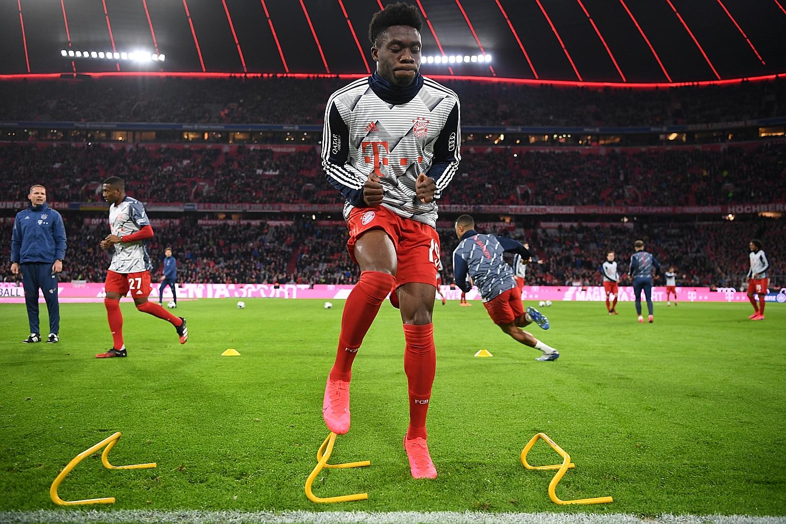 With team training (above, Bayern Munich's Alphonso Davies warming up before their match against RB Leipzig last month) suspended, Bayern now have "cyber training" sessions where players work out together online. 