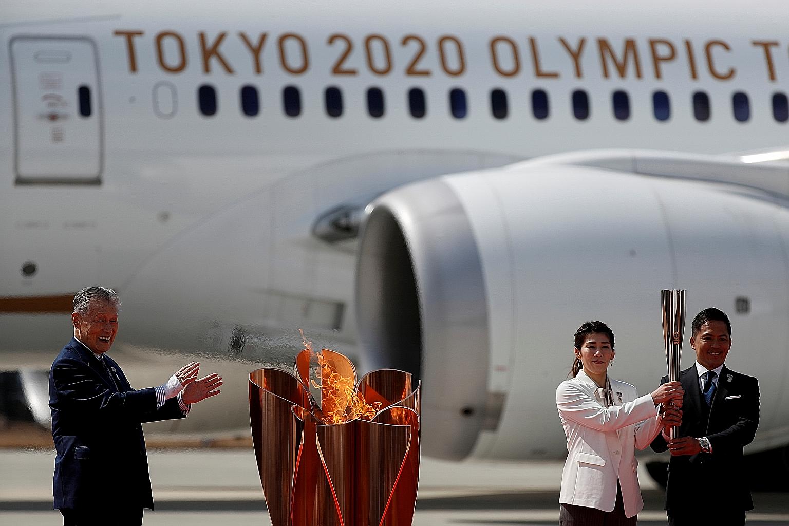 Three-time Olympic champions Tadahiro Nomura and Saori Yoshida posing after lighting the Olympic cauldron, while Tokyo 2020 president Yoshiro Mori watches during a ceremony at Japan Air Self-Defence Force Matsushima Base in Miyagi prefecture yesterday. Th