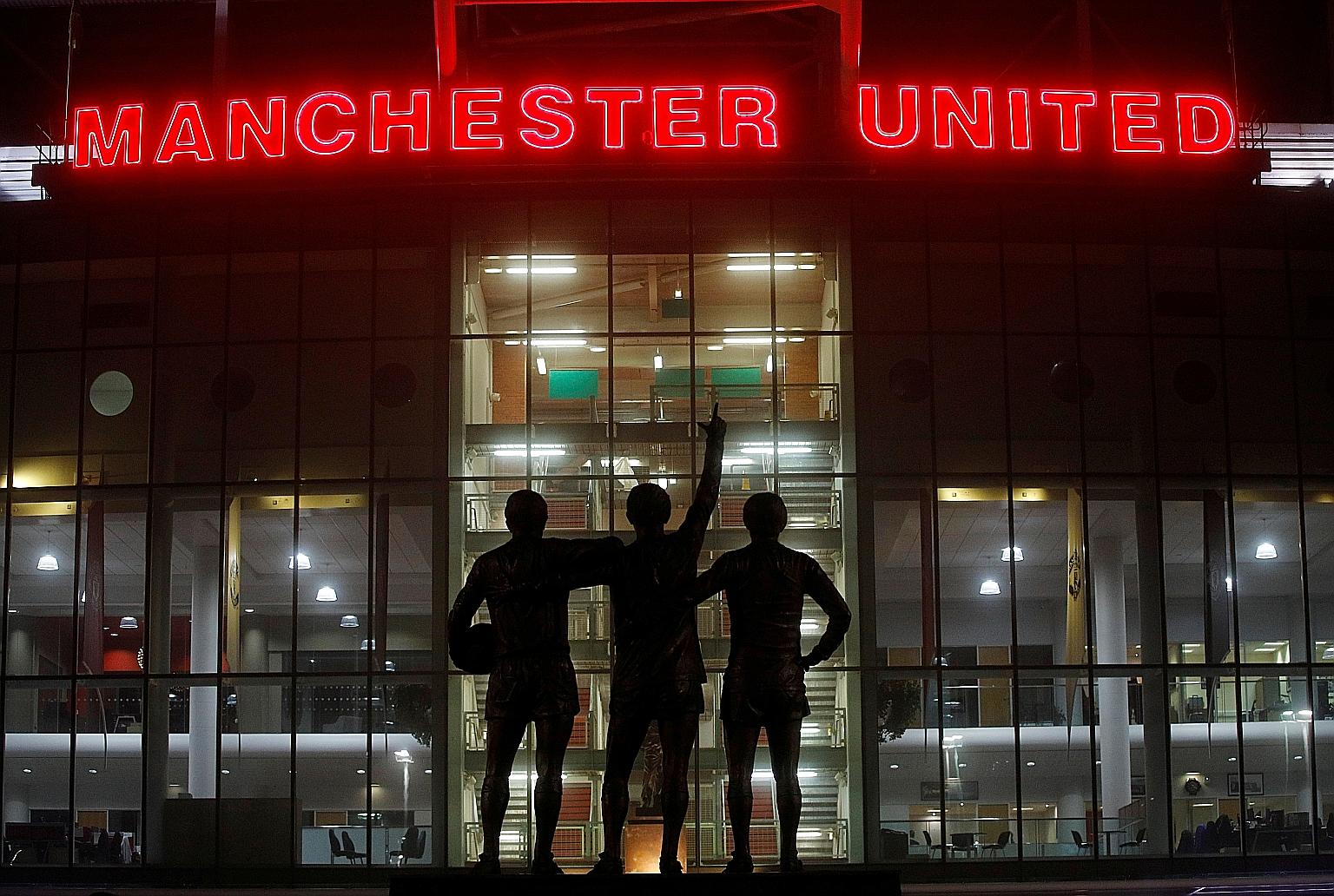 The statue of Manchester United's Holy Trinity of Bobby Charlton, George Best and Denis Law outside Old Trafford. United say they will keep paying their casual staff during the suspension of the Premier League.