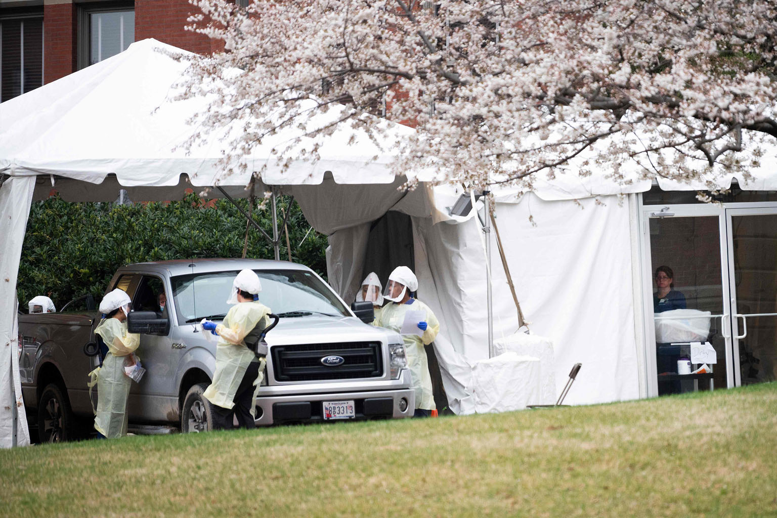 US medical workers conducting doctor prescribed drive-through testing for Covid-19 on Thursday at Johns Hopkins Hospital in Baltimore, Maryland. The mask shortages in US hospitals stem mainly from the prolonged outbreak in China and a widespread buyi