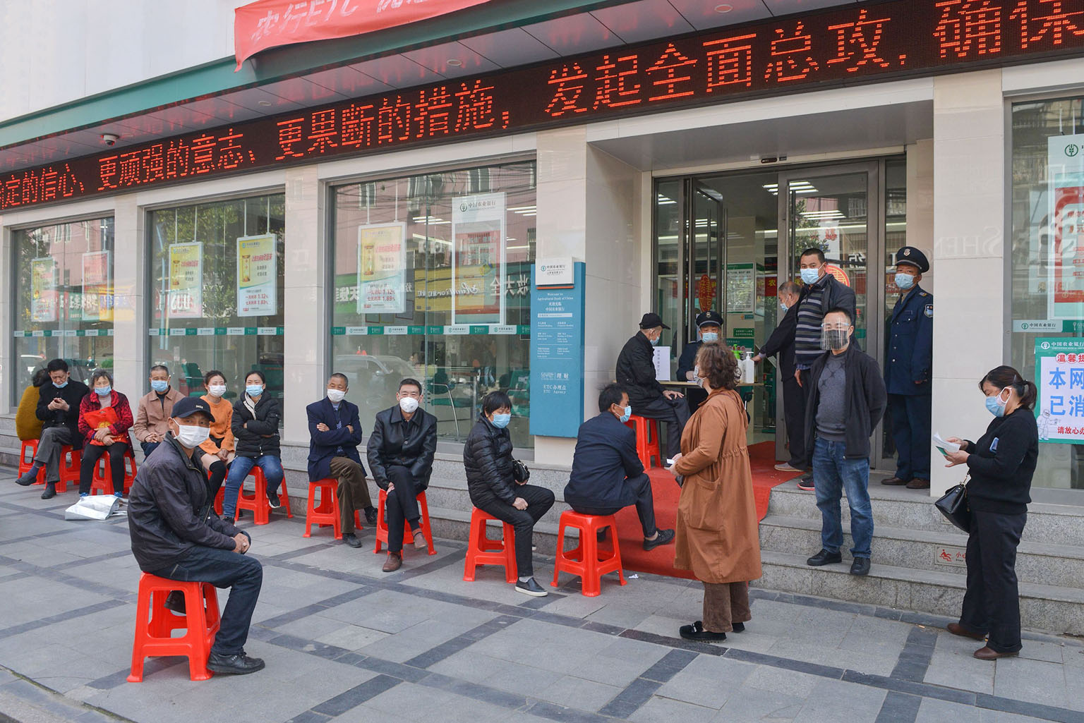Customers queueing to have their temperature taken before entering a bank in Yunmeng county, in Xiaogan city, Hubei province, on Thursday. All 39 new coronavirus cases reported in China yesterday were imported. PHOTO: AGENCE FRANCE-PRESSE