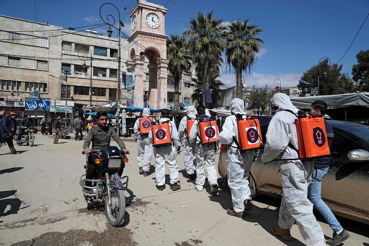 Members of Syrian non-governmental organisation Violet disinfecting streets in north-western Idlib city last Saturday as a preventive measure against the spread of the coronavirus. Evoking the "potentially devastating impact" of Covid-19 in Idlib and