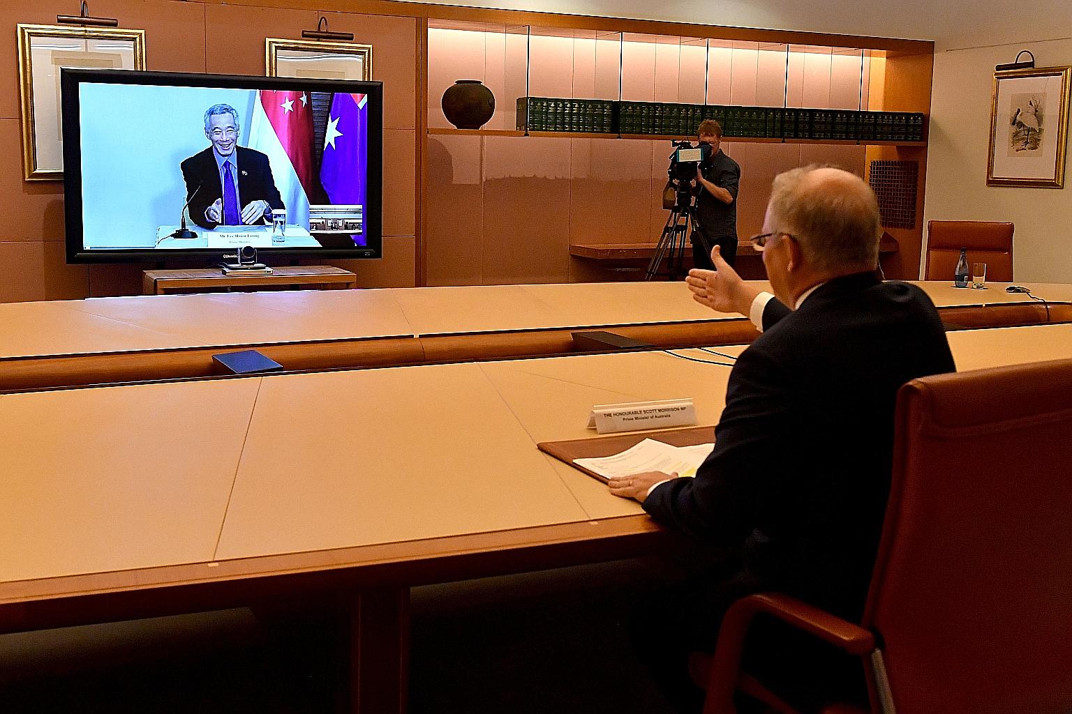 Singapore's Prime Minister Lee Hsien Loong and Australia's Prime Minister Scott Morrison holding their hands out for a virtual handshake during their video conference yesterday.