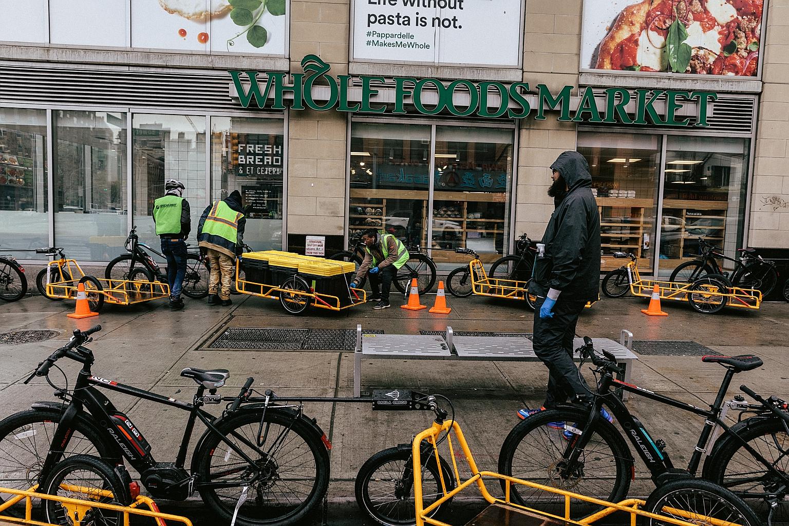 Online orders are loaded onto bikes at Whole Foods in Manhattan. The coronavirus pandemic has caused a surge in demand for grocery deliveries.