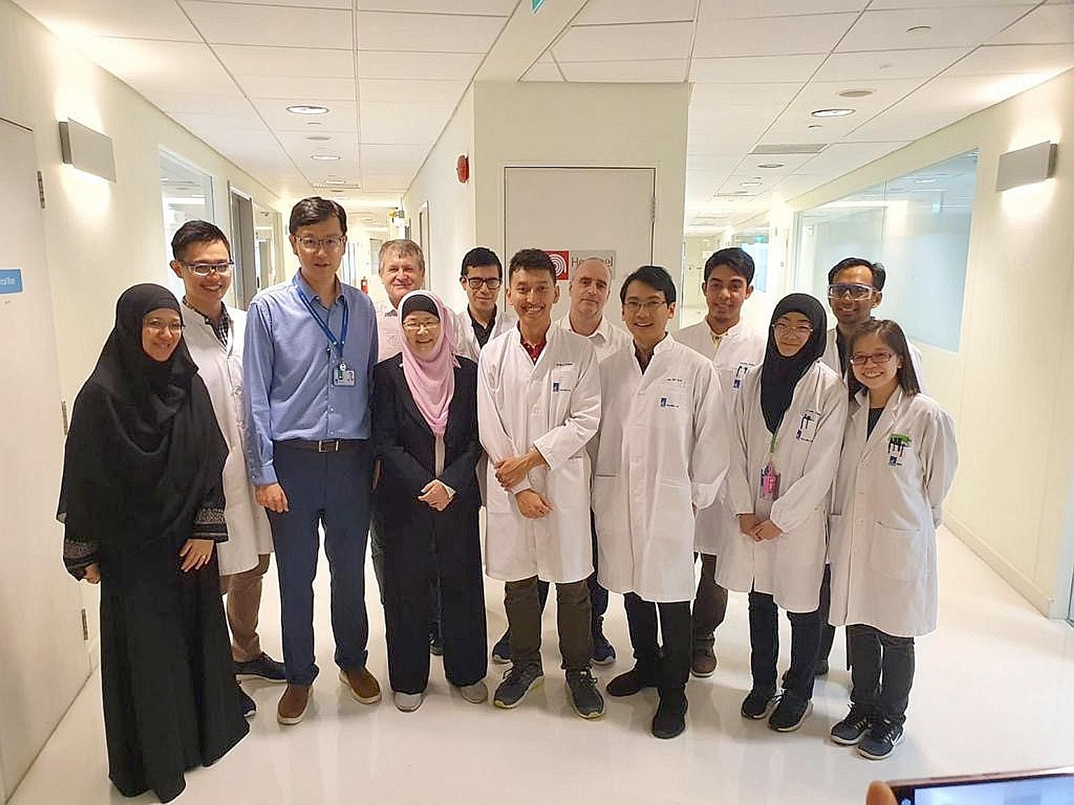 Professor Jackie Ying (in pink headgear), the head of A*Star's NanoBio Lab, said she and her team of scientists have been working tirelessly for around six weeks to come up with a rapid test that can tell if a person has Covid-19 in as little as five