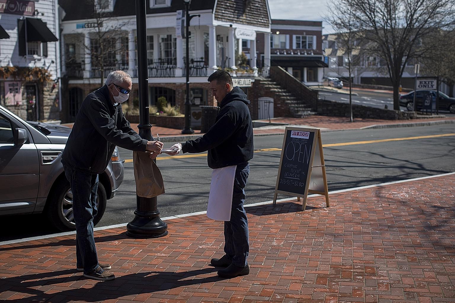 Mr Mitch Palais, 59, picking up a takeaway order from Rye Ridge Deli in Westport, in the US state of Connecticut, on Sunday. Mr Palais was tested for Covid-19 but, as of Sunday, had yet to receive results. Westport, a town of 28,000 in Fairfield Coun