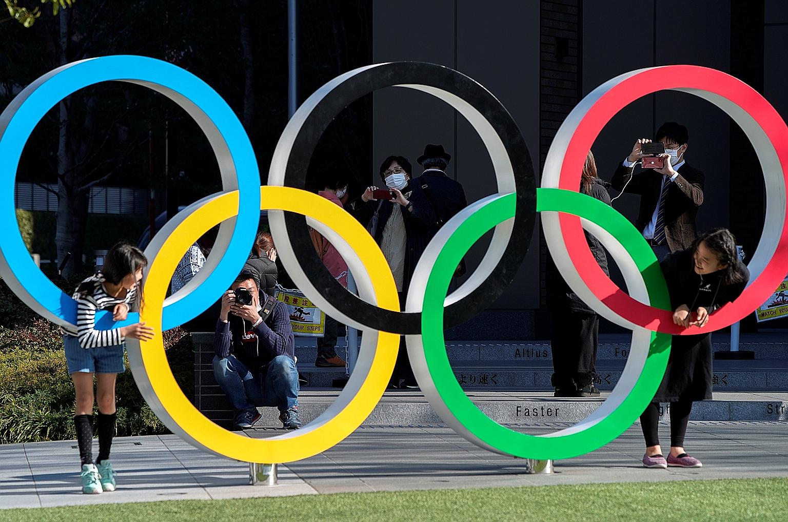 Visitors posing at the Olympic rings in front of the Japan Olympic Museum in Tokyo, yesterday. The Tokyo 2020 Olympic Games have been delayed to "a date beyond 2020 but not later than summer 2021". The new dates have not yet been set.