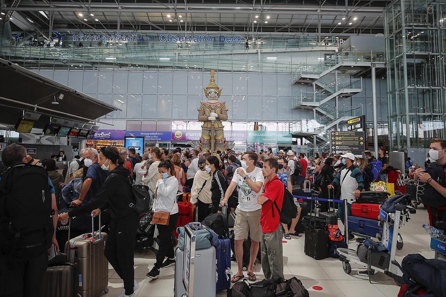 Travellers at the check-in counter of Suvarnabhumi international airport in Bangkok on Wednesday. Thailand has banned the entry of foreigners, with the exception of those residing and working in the country as well as diplomats, as part of the govern