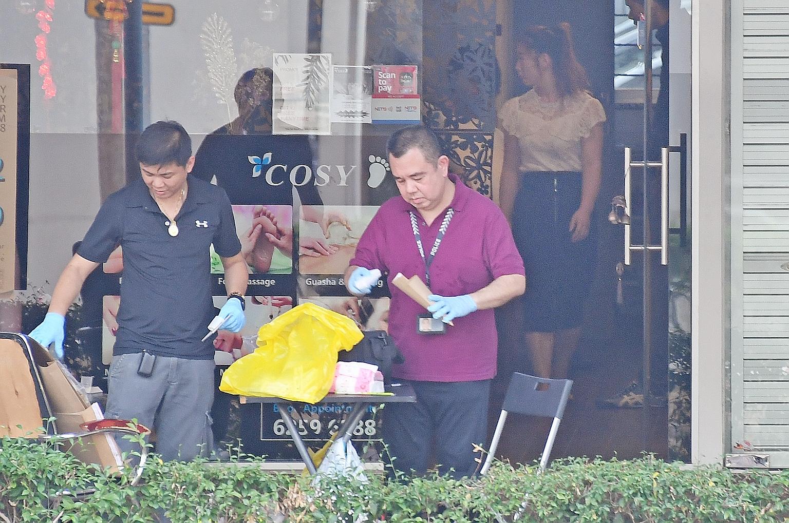 Police personnel collecting evidence from Cozy Spa at Block 532 Ang Mo Kio Avenue 5, where Danon Tay Kok Lee threatened three women with a penknife and Yeo Shuxing removed the spa's closed-circuit television camera. They were there to look for the "b