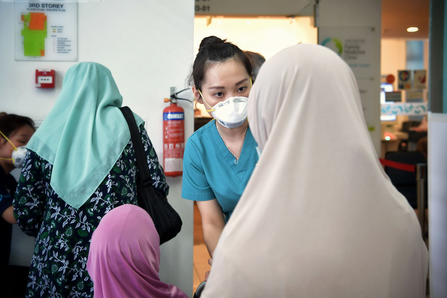 A triage nurse taking a patient's temperature at the Ang Mo Kio Family Medicine Clinic. Deputy Prime Minister Heng Swee Keat acknowledged healthcare workers on the front line as well as private sector organisations, individuals and even foreigners wh