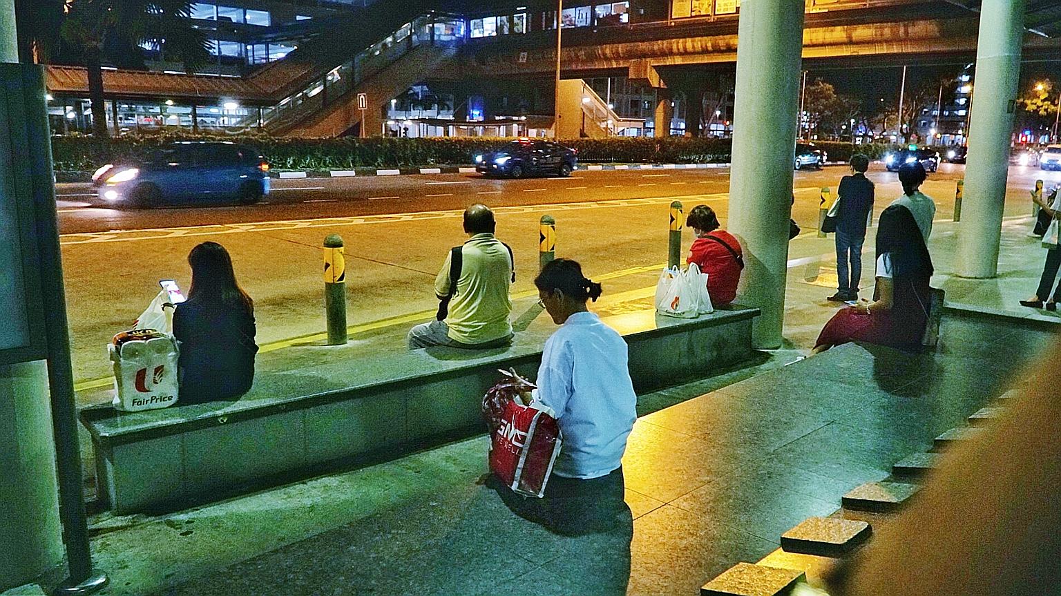 Commuters observing safe distancing at a bus stop near Admiralty MRT station. As Singapore battles a second surge of Covid-19 cases, many of whom are returning residents or long-term pass holders, bars and other entertainment outlets have been ordere