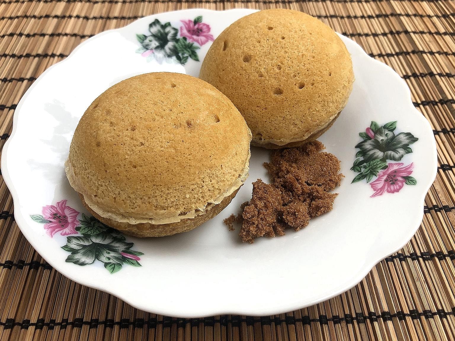Homemade steamed sponge cakes served with a side of brown sugar.