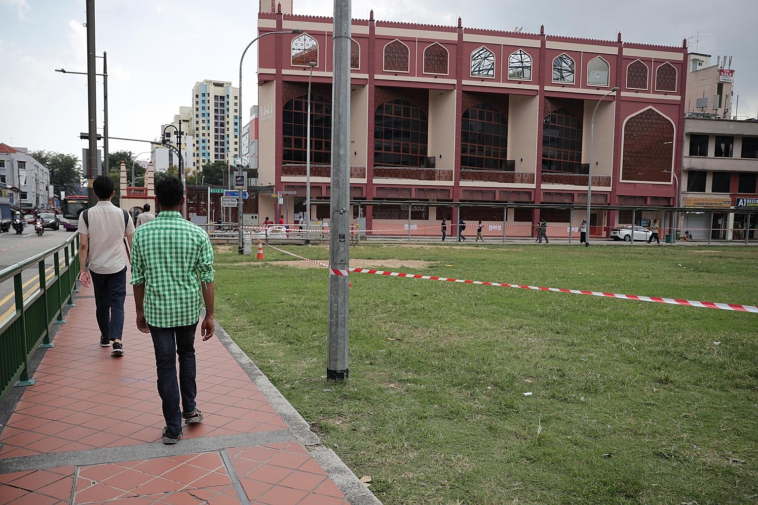 An open field near Angullia Mosque in Little India, where foreign workers usually gather, lay empty after being cordoned off by Manpower Ministry officers yesterday. ST PHOTO: GIN TAY