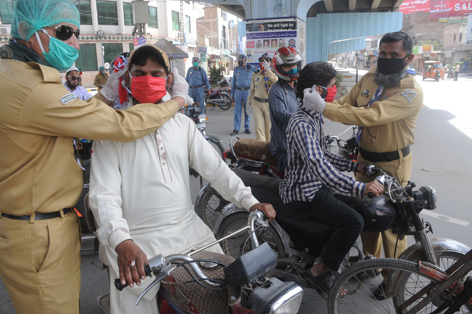 Volunteers distributing face masks to people during a partial lockdown in Multan, Pakistan, on Sunday. Public health infrastructure in India, Pakistan or any number of sub-Saharan African countries is already struggling to cope, even at this relative