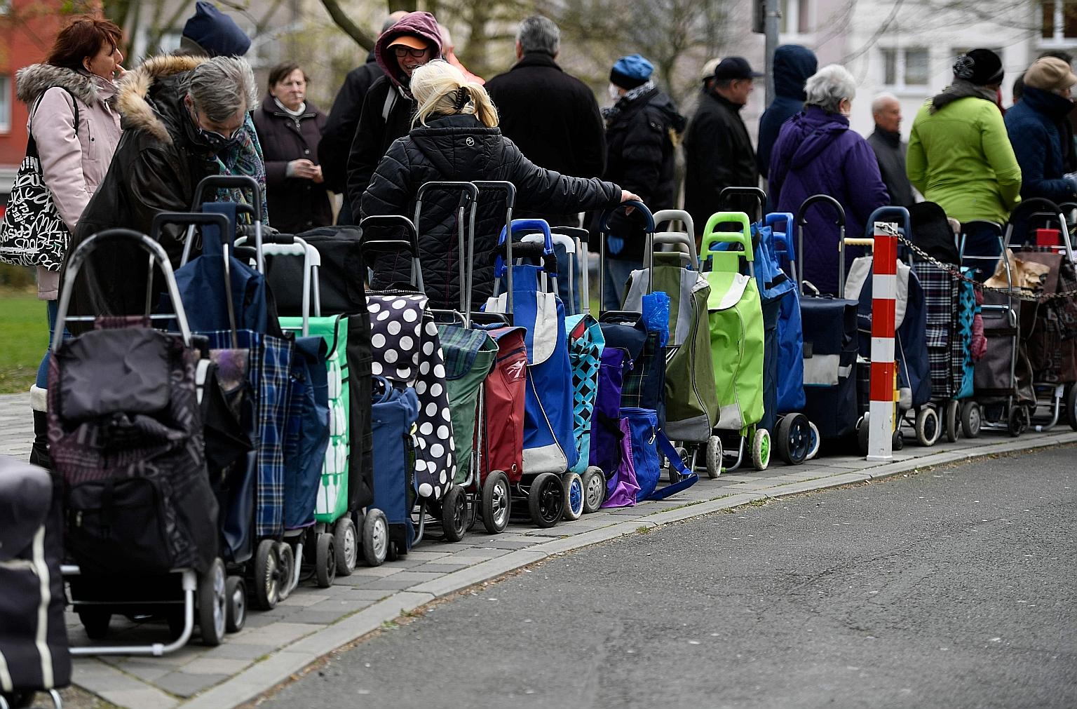 Recipients of a German food bank waiting to pick up supplies earlier this week. Fears are growing that the downturn could be far more punishing than initially feared, as governments intensify restrictions on business to halt the spread of the pandemi