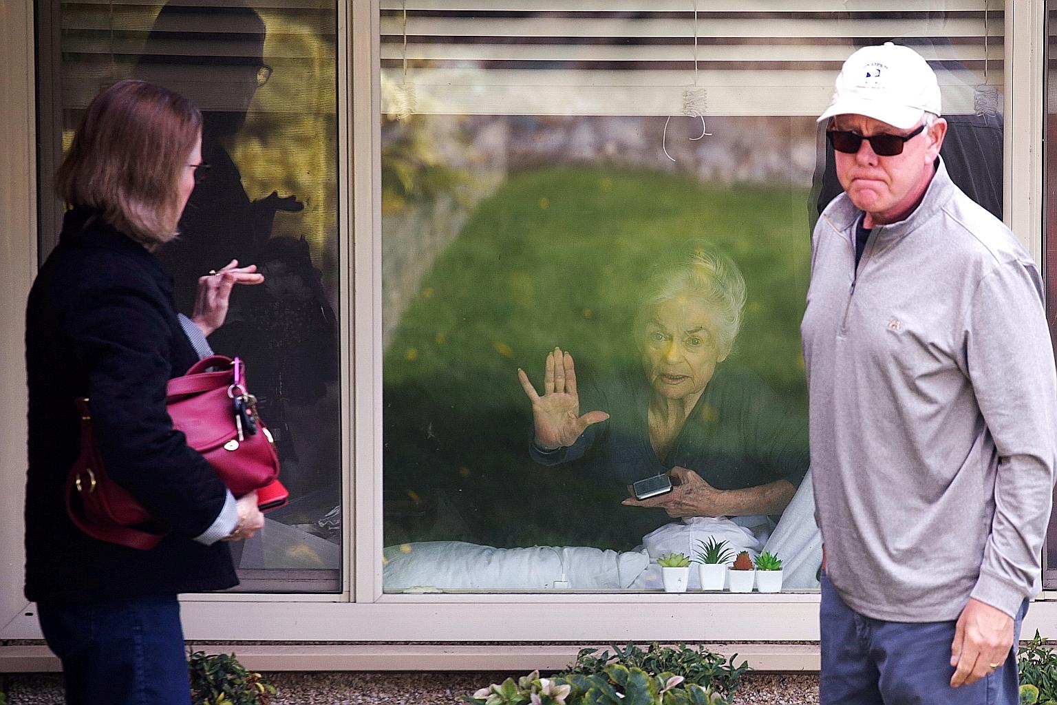 Ms Judie Shape, 81, who tested positive for coronavirus, waving goodbye to her daughter Lori and son-in-law Michael Spencer who visited outside her room at Life Care Centre in Kirkland, Washington. The facility was the epicentre of an outbreak in the